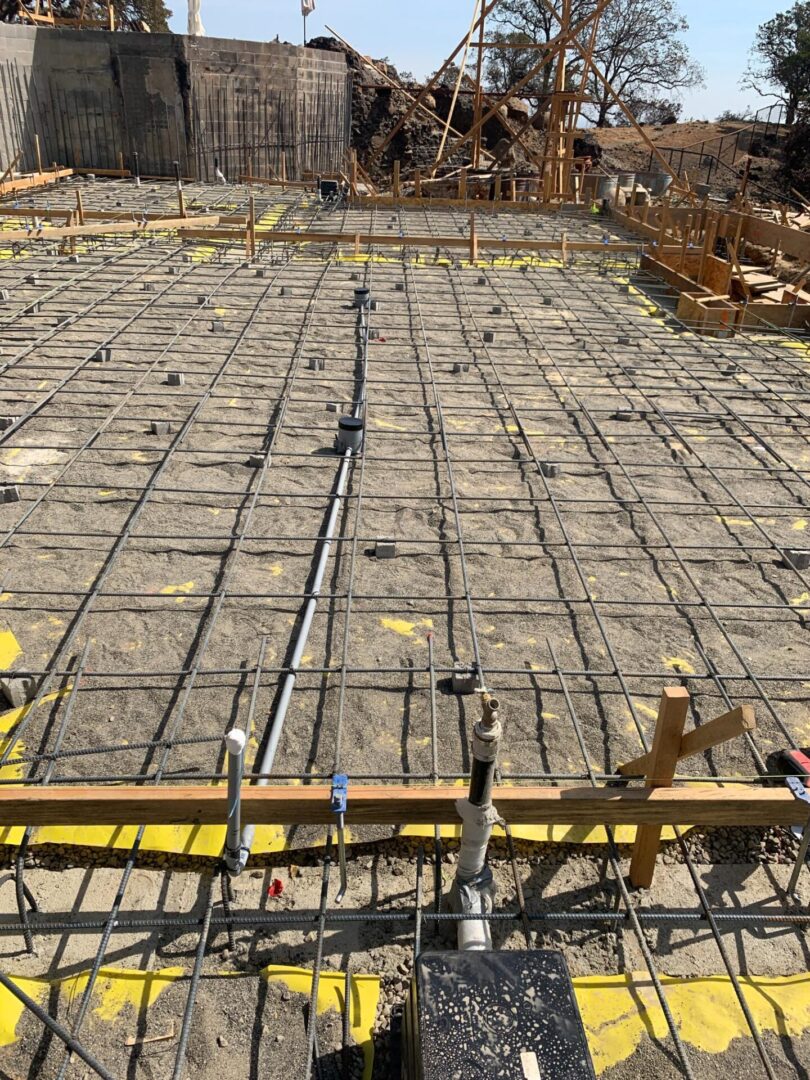 A concrete slab being poured with yellow scaffolding.