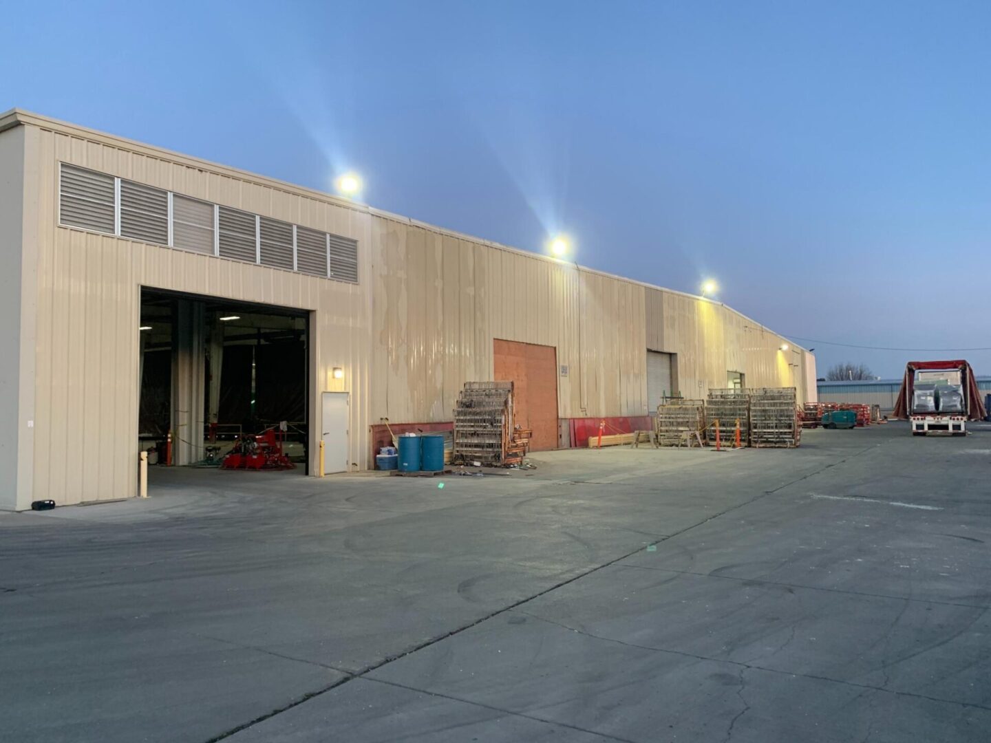 A large warehouse with many lights on the side.