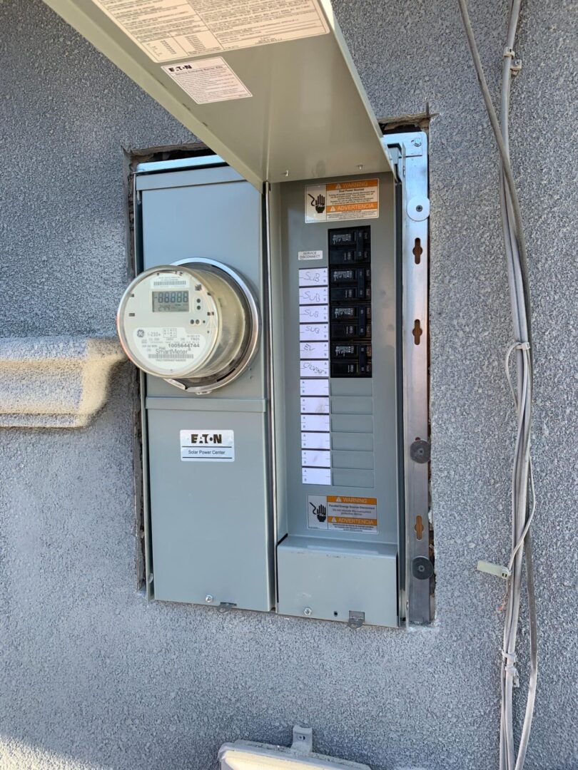 A close up of an electrical panel with a meter