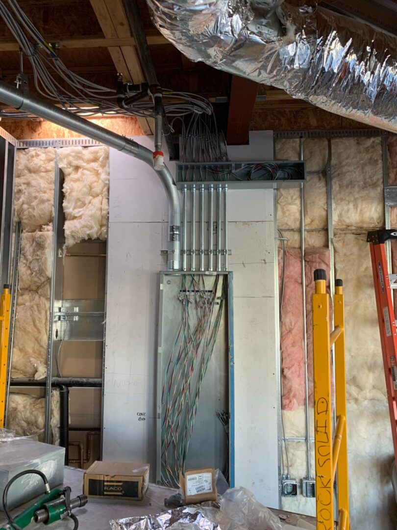 A room with many pipes and wires hanging from the ceiling.