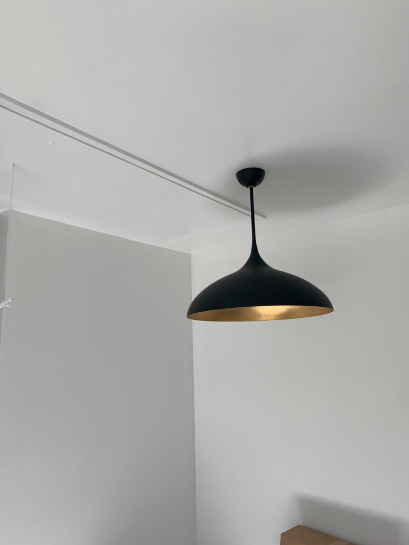 A black lamp hanging from the ceiling in a room.