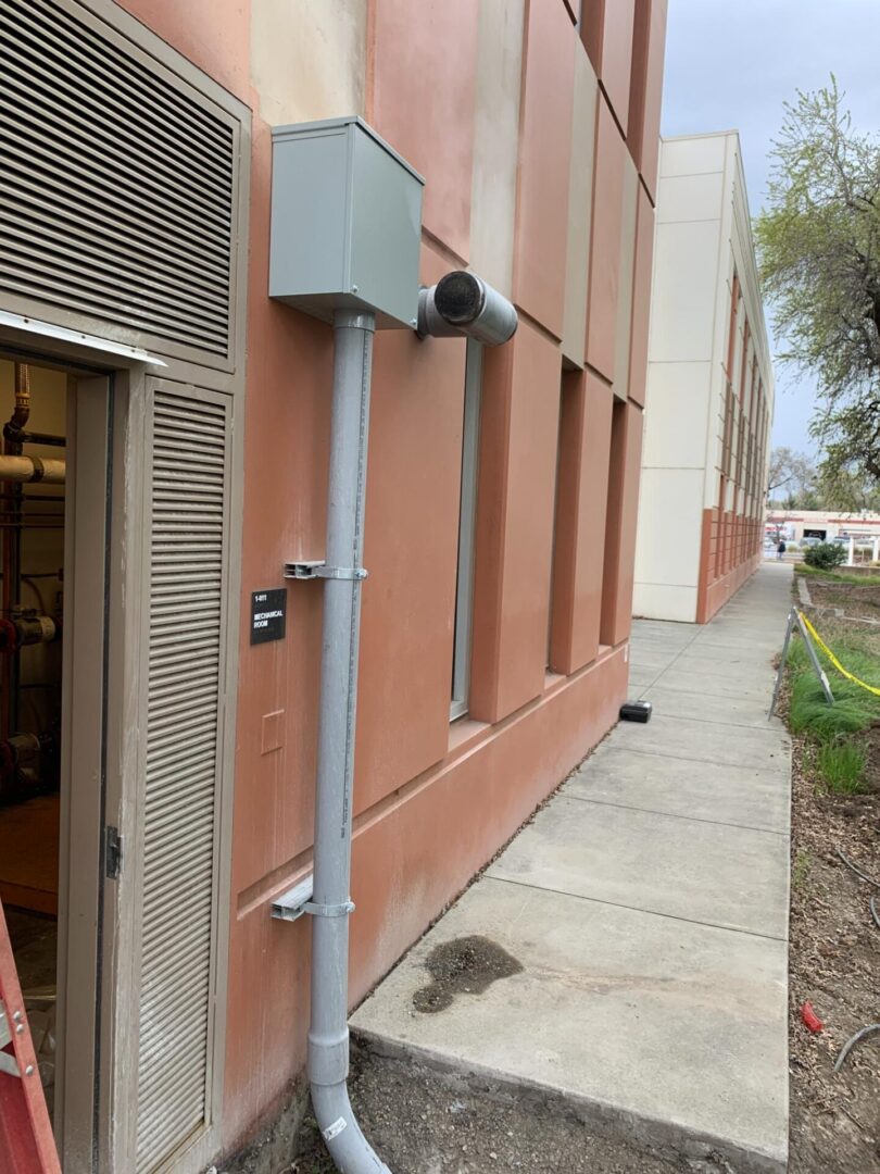 A building with a metal pole on the side of it.