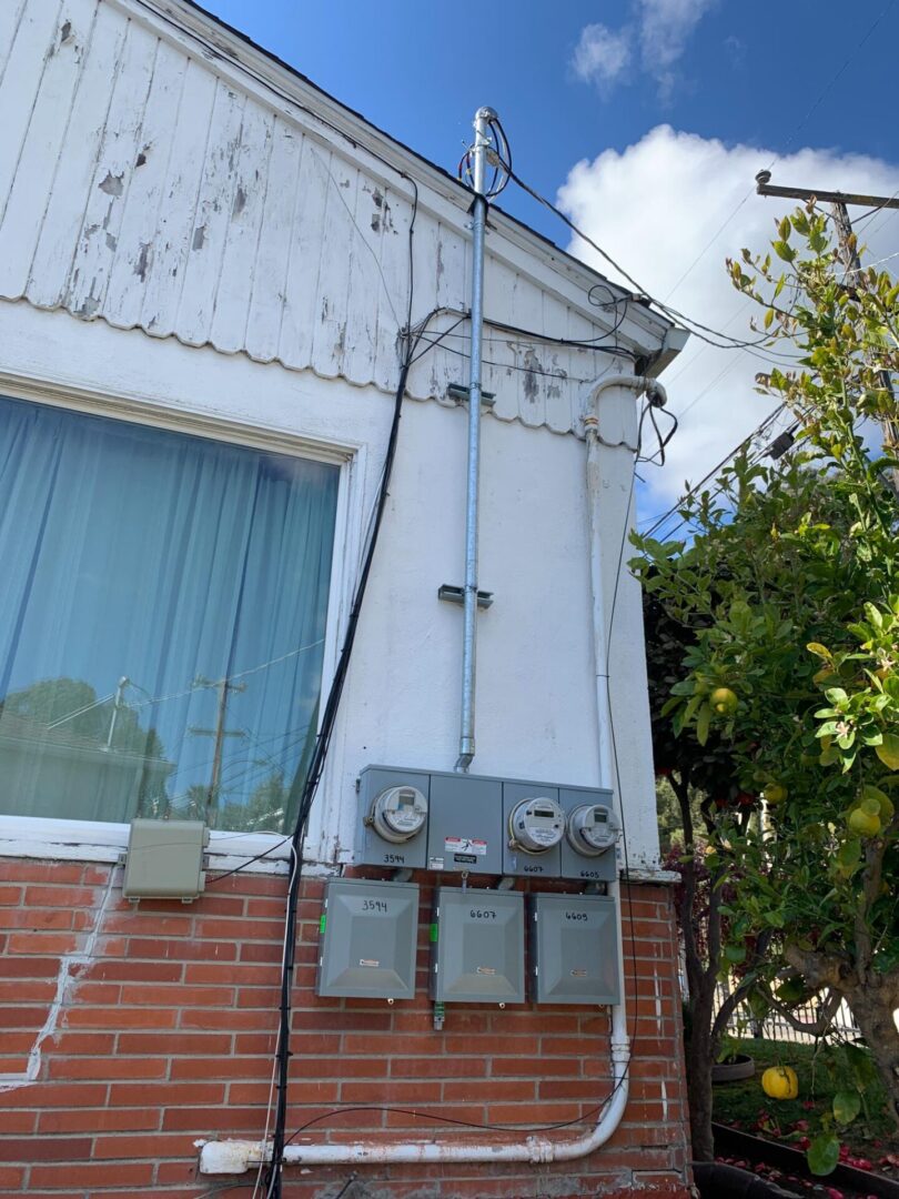 A white brick building with power lines hanging from it.