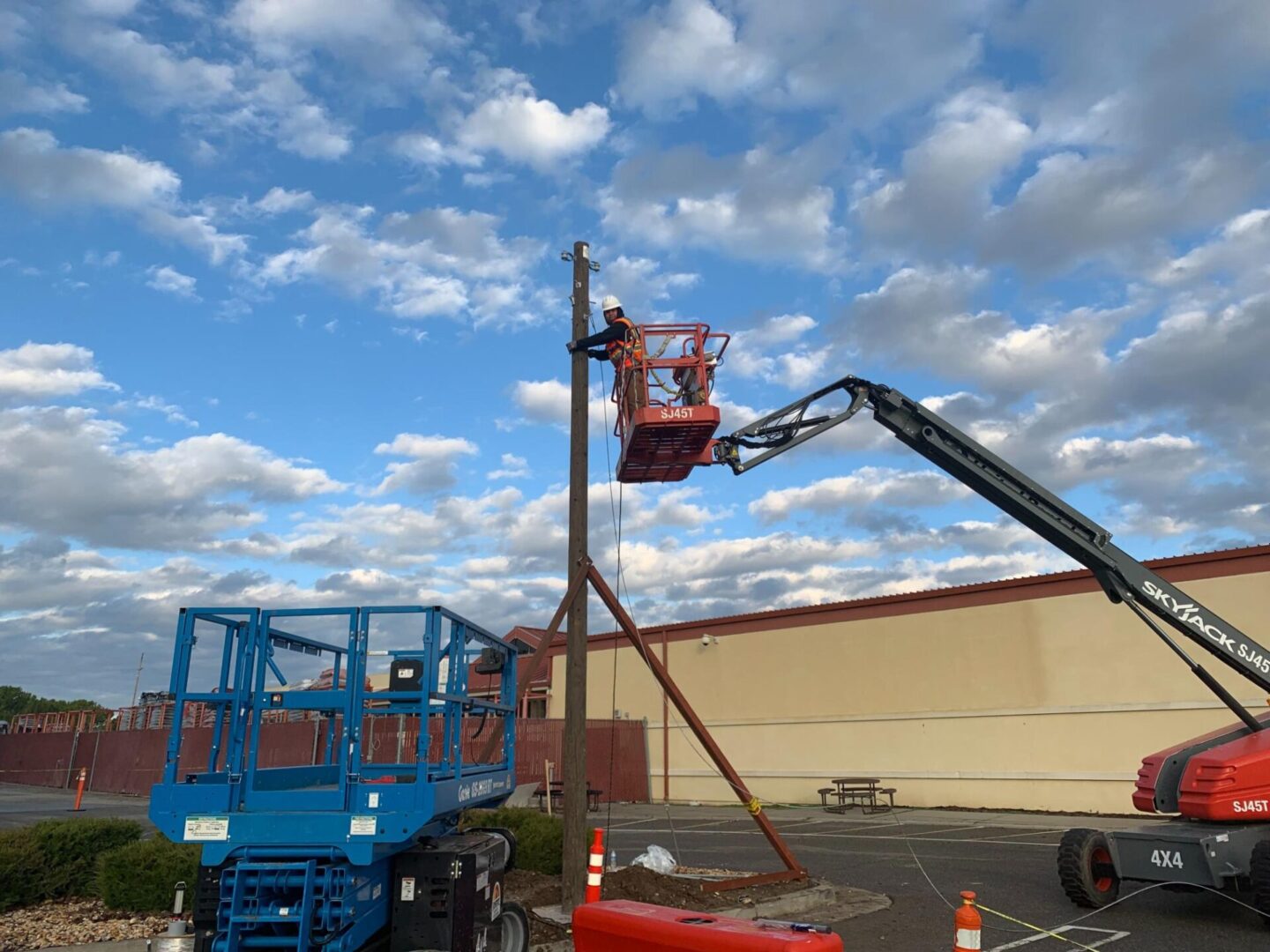 A man on a cherry picker working on the side of a building.