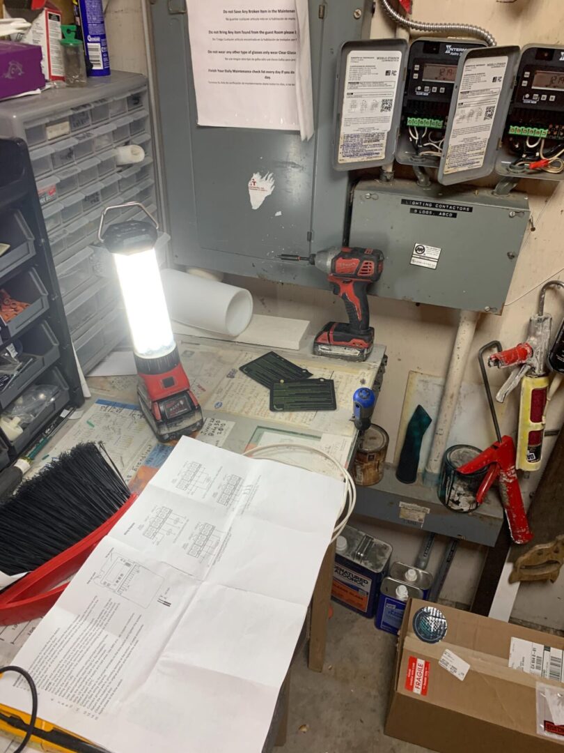 A cluttered work area with tools and papers.