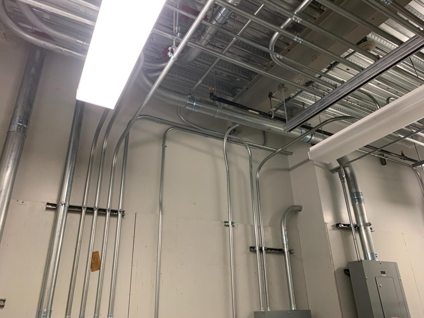 A room with many pipes and wires hanging from the ceiling.