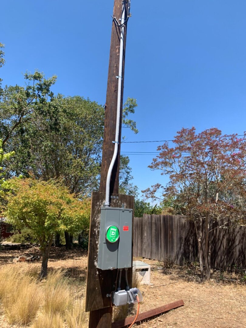 A telephone pole with wires hanging from it.