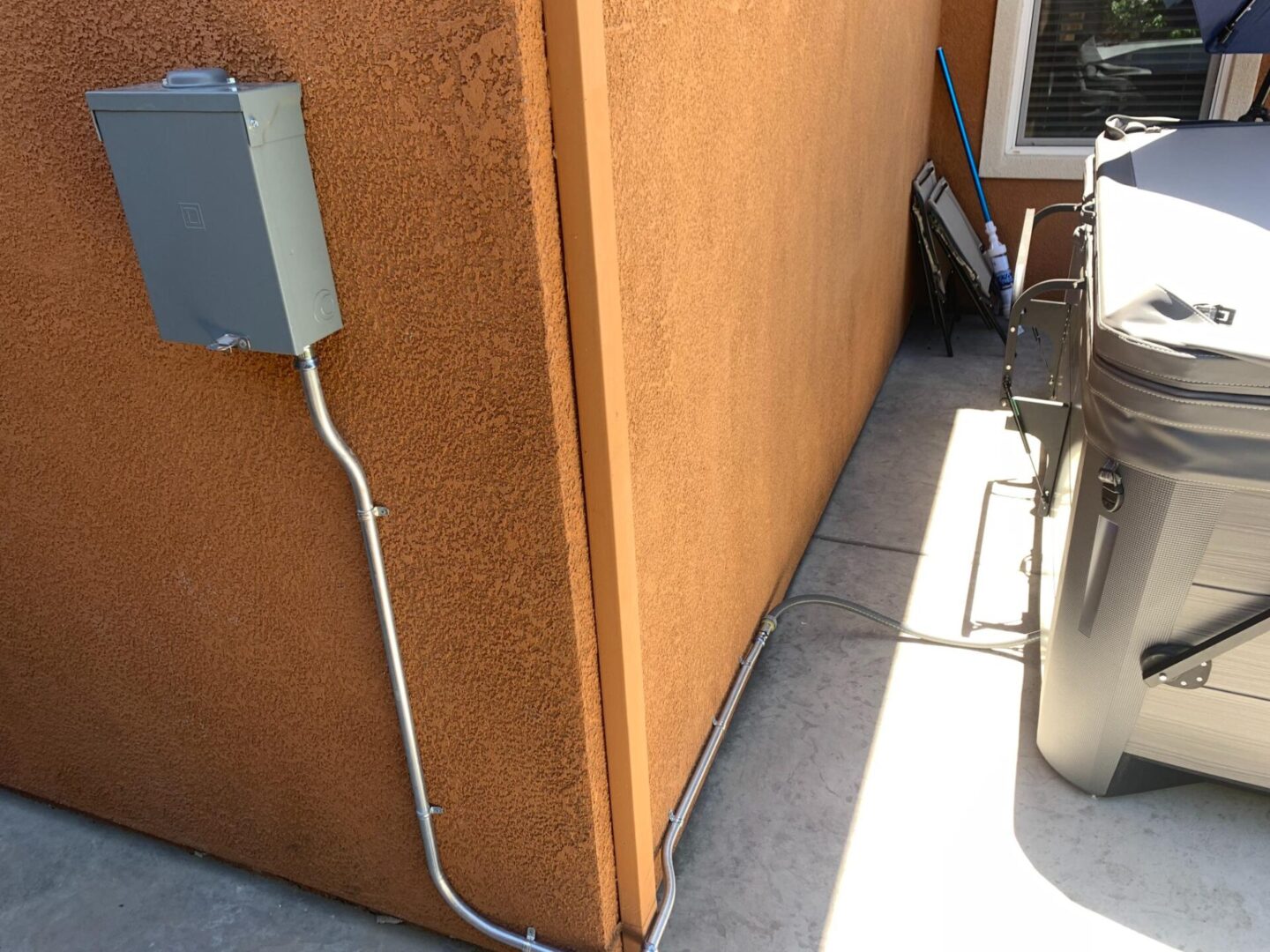 A utility box and electrical wiring on the side of a building.