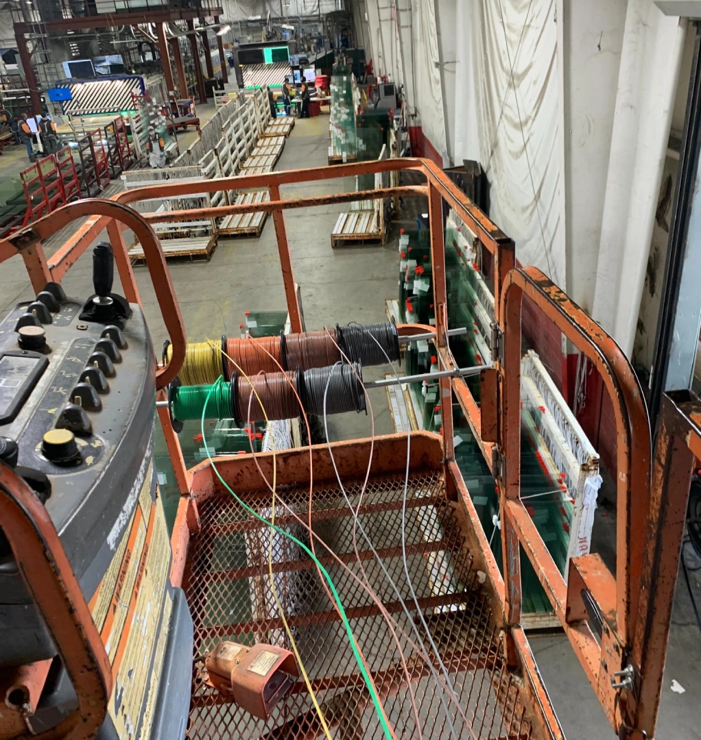 A large machine in an industrial setting with many wires.